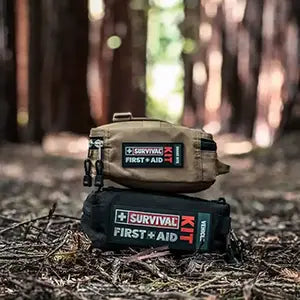 SURVIVAL Vehicle and Snake Bite Kits sitting in the woods.